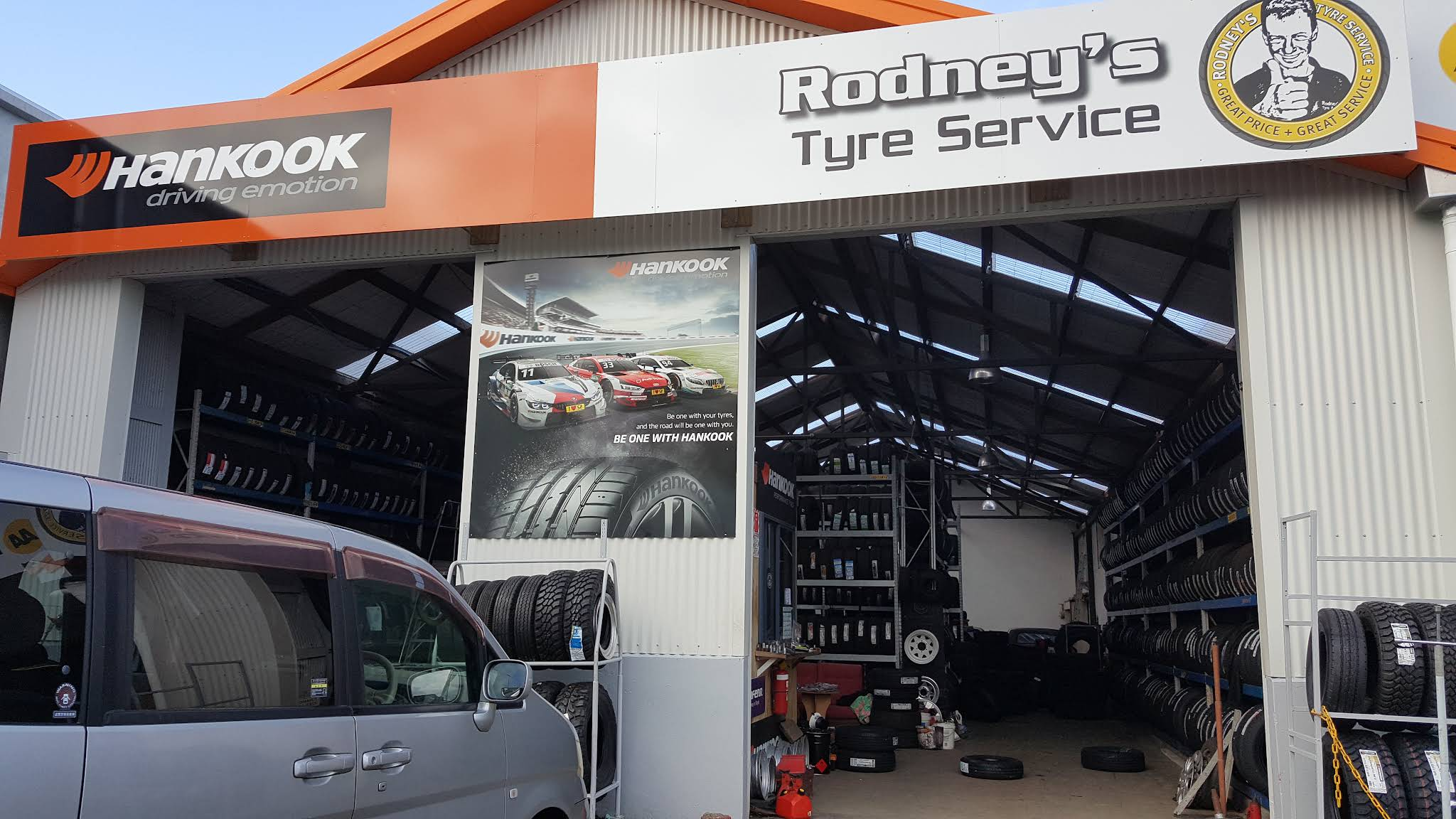 Rodney's Tyre Service shopfront on Hobson Street, New Plymouth, with Hankook signage and racks of tyres in the open workshop